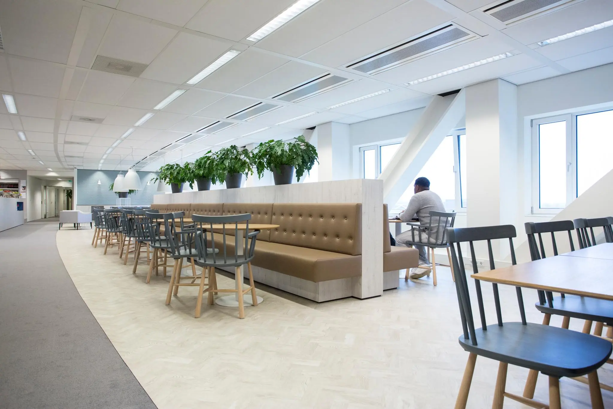 Moderne en lichte bedrijfsruimte aan Rivium Boulevard met zitplaatsen, tafels en planten.